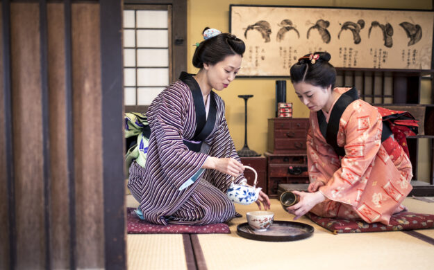 Two women pour tea
