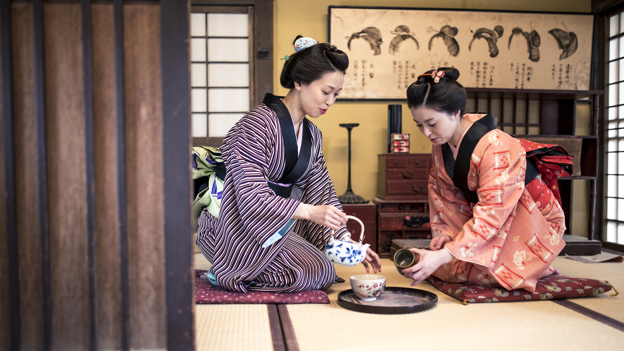 Two women pour tea