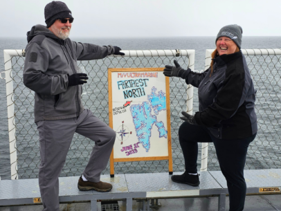 Journeys Adventure Specialist Lene stands with a map on an Arctic expedition.