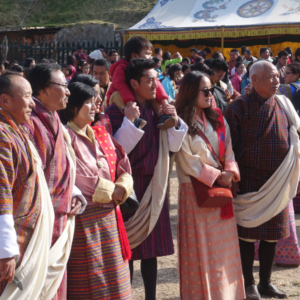 People gather at a festival in Bhutan wearing bright colors.